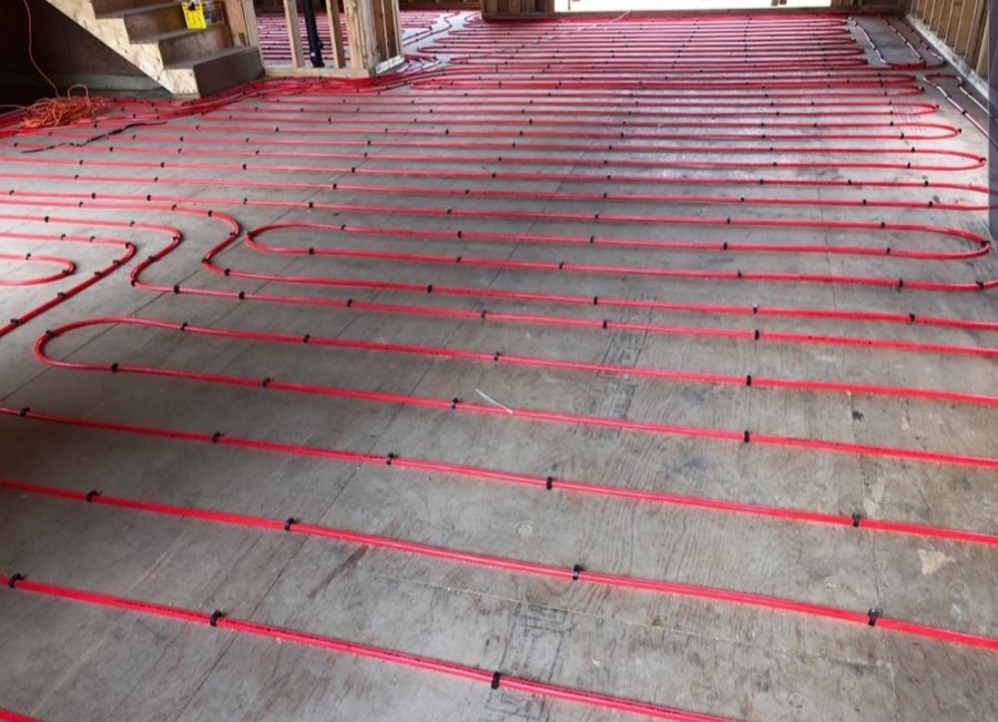 In-floor radiant heating loops pinned across a concrete slab