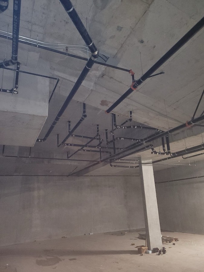 Pipework fixed to the ceiling of a concrete parkade